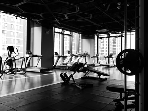 A modern gym floor with treadmills and weight benches